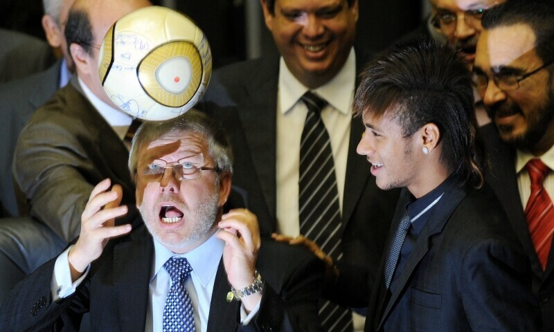(FILES) Marco Maia (L), president of Brazil’s Lower House president, heads a ball as Santos soccer player Neymar (R) watches during a special Congress session to celebrate the club’s 100th anniversary in Brasilia April 10, 2012. — AFP