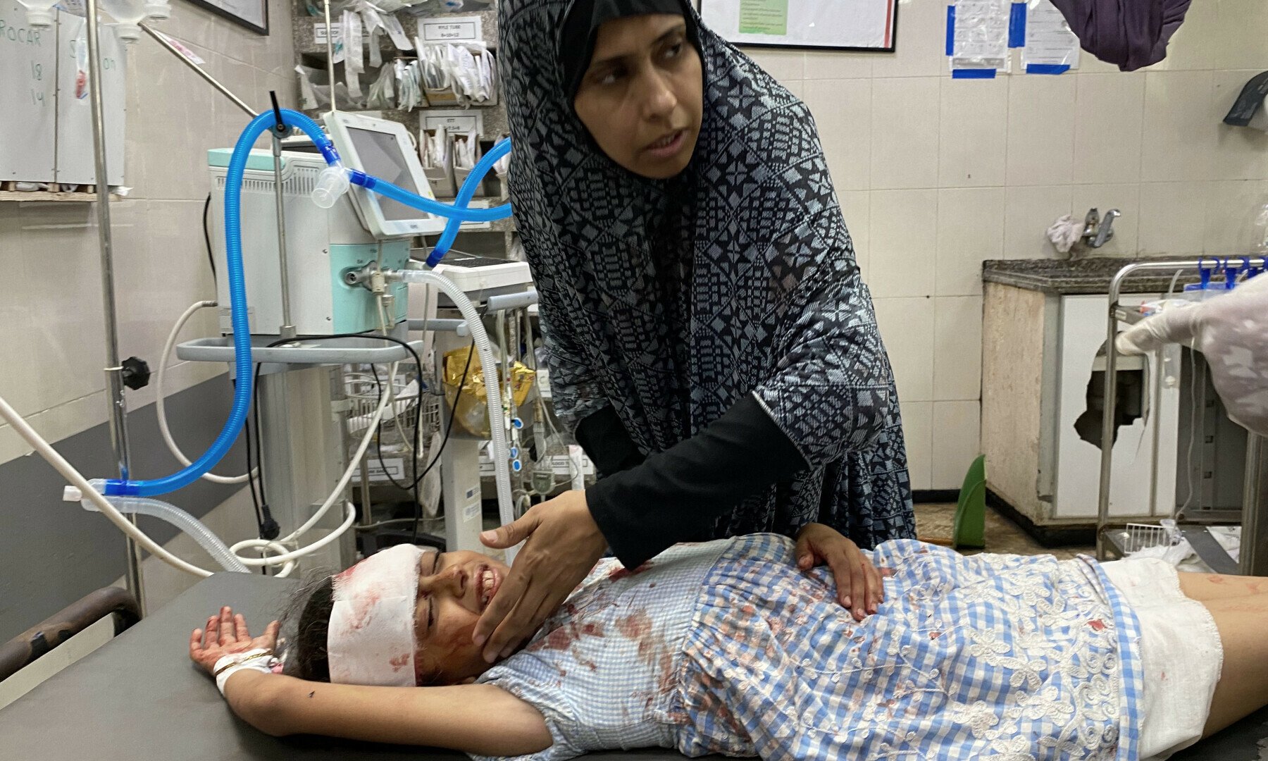  A girl talks to her mother as she receives treatment for her wounds, sustained in an Israeli strike on a camp housing displaced Palestinians, at Khan Younis’s Nasser hospital in the southern Gaza Strip on July 2, 2025. — AFP 