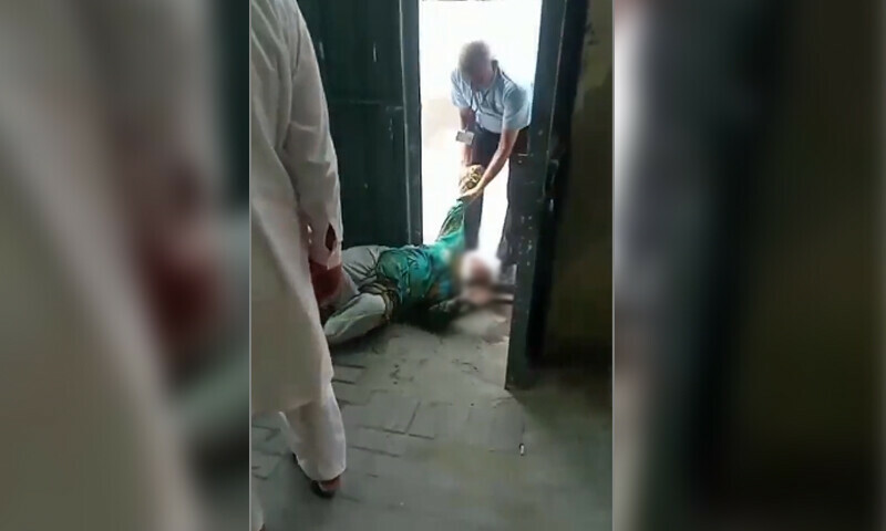 A Lesco guard drags an elderly woman along the ground by her arm while removing her from a Lesco office in Sheikhupura, Punjab on June 30. &mdash; screengrab