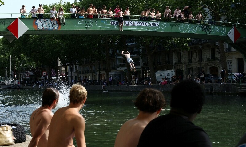 Young people jump from a bridge into the Canal Saint-Martin on a sunny and warm summer day in Paris as an early summer heatwave hits France, July 2. — Reuters Young people jump from a bridge into the Canal Saint-Martin on a sunny and warm summer day in Paris as an early summer heatwave hits France, July 2. — Reuters