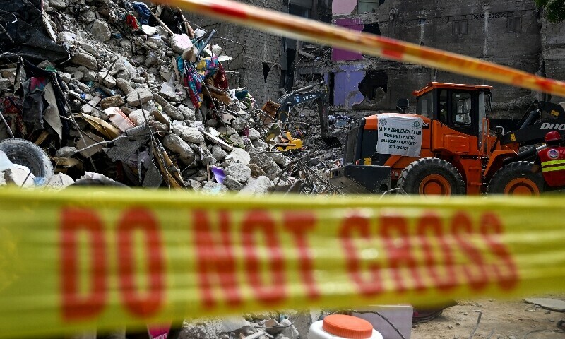 A rescue worker is pictured during a search operation amidst the debris of a collapsed building in Karachi on July 5. — AFP