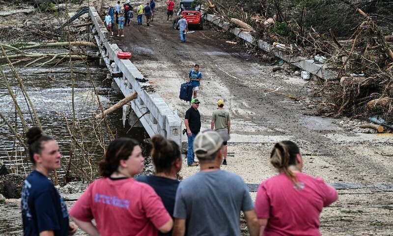 People look on as law enforcement and volunteers continue to search for missing people near Camp Mystic, the site of where at least 20 girls went missing after flash flooding in Hunt, Texas, on July 5. — AFP