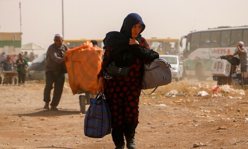 Afghan refugees arrive from Iran at Islam Qala border between Afghanistan and Iran, on July 5.  — AFP