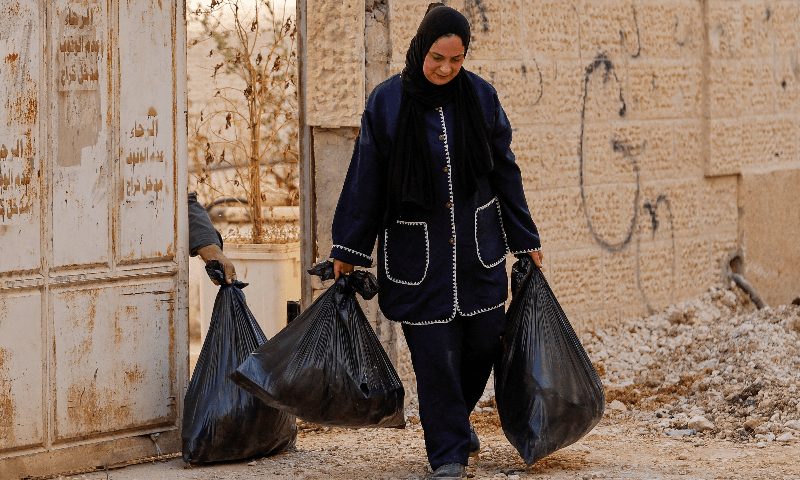 A Palestinian woman carries her belongings, after collecting them from her house, during Israeli military operation, at the entrance of Jenin camp, in the Israeli-occupied West Bank, on July 8, 2025. — Reuters