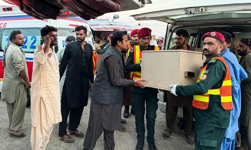 Rescue personnel transfer the body of a bus passenger into an ambulance at the Zhob district in Balochistan, July 11. — AFP