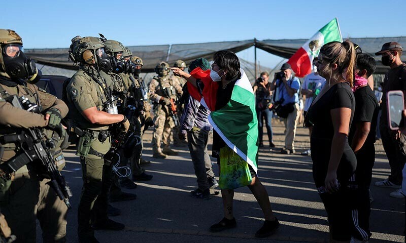 A demonstrator draped in a Mexican flag gestures at US federal agents blocking a road leading to an agricultural facility where US federal agents and immigration officers carried out an operation, in Camarillo, California, US on July 10. — Reuters/File