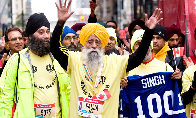 This photograph obtained on October 17, 2011 by courtesy of Scotiabank Toronto Waterfront Marathon in Toronto, Ontario shows inspirational British Sikh, 100 year-old Fauja Singh (C) as he completes the 42.2km 2011 Scotiabank Toronto Waterfront Marathon on October 16, 2011. — Reuters