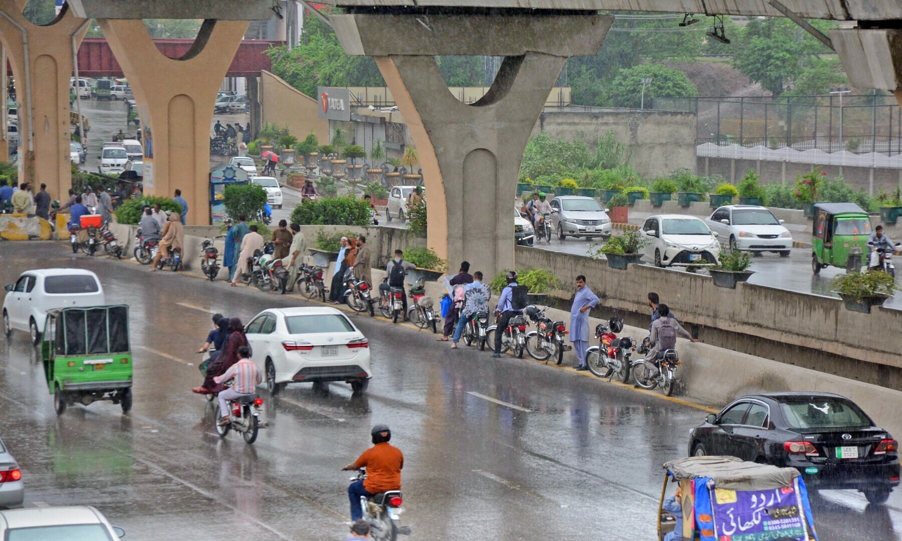 Motorcyclists stand under the shade of Metro Bus track during rain in Rawalpindi. —. Online photo by Raja Asim Motorcyclists stand under the shade of Metro Bus track during rain in Rawalpindi. —. Online photo by Raja Asim