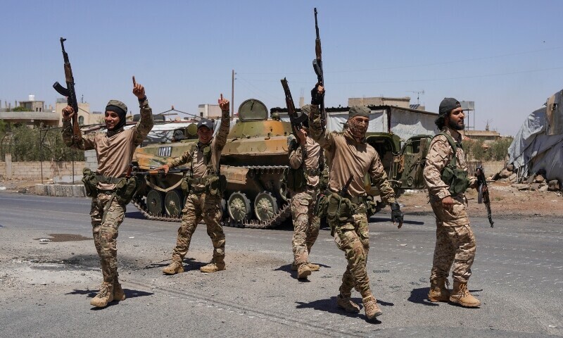 Syrian security forces walk together along a street, after clashes between Syrian government troops and local Druze fighters resumed in the southern Druze city of Sweida, July 16. — Reuters