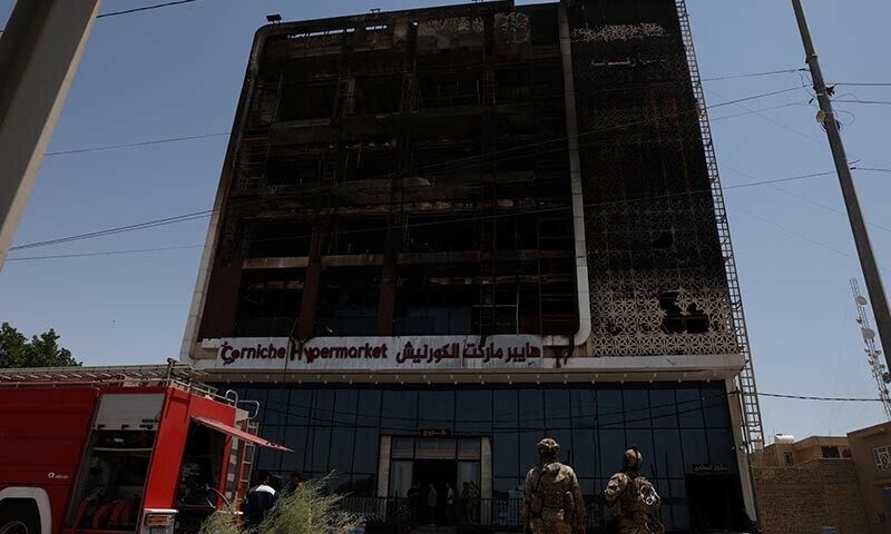 A fire truck stands next to the wreckage of a five-storey shopping center, after a massive overnight fire killed dozens of people, in al-Kut, Wasit province, Iraq on July 17, 2025. — Reuters