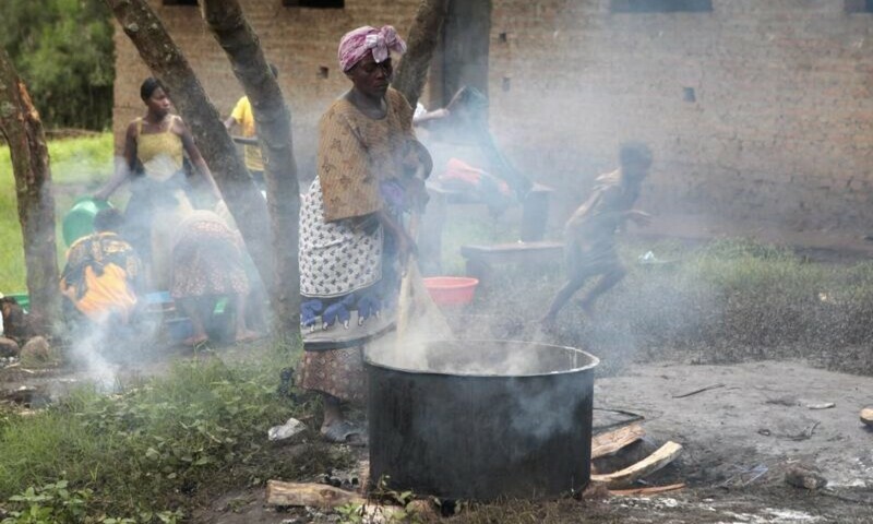 A woman prepares a meal at a school, where people displaced by the torrential rains are sheltered, in Kasese district, southwest from the capital Kampala, Uganda. — Reuters/File