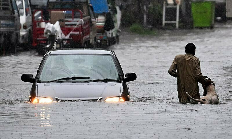 A man along with his dog while a car wade through a flooded street during heavy monsoon rains in Rawalpindi on July 17, 2025. — AFP/File A man along with his dog while a car wade through a flooded street during heavy monsoon rains in Rawalpindi on July 17, 2025. — AFP/File