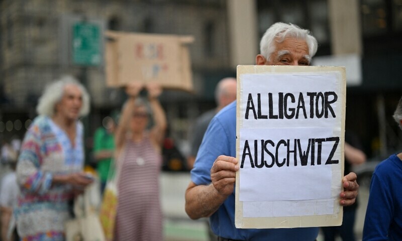 A man holds a sign referring to a newly-opened migrant detention center in the Florida Everglades on July 17. &mdash; AFP