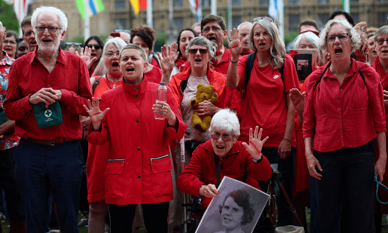 Members of the public gather in Parliament Square wearing red and holding items behind a giant &lsquo;Red Line for Gaza&rsquo; banner to symbolise what is being lost due to the conflict, in London, Britain, on July 22. &mdash; Reuters