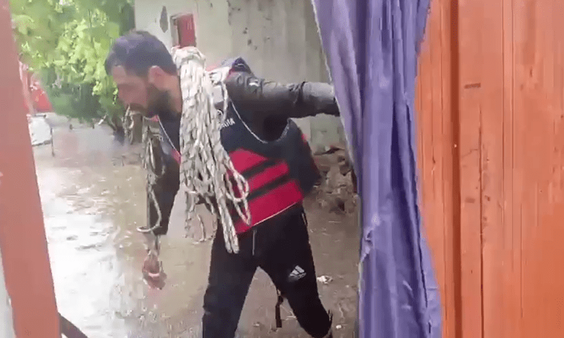 Image showing a rescue worker during a rescue operation in Swat. — Screengrab from video via Umar Bacha Image showing a rescue worker during a rescue operation in Swat. — Screengrab from video via Umar Bacha