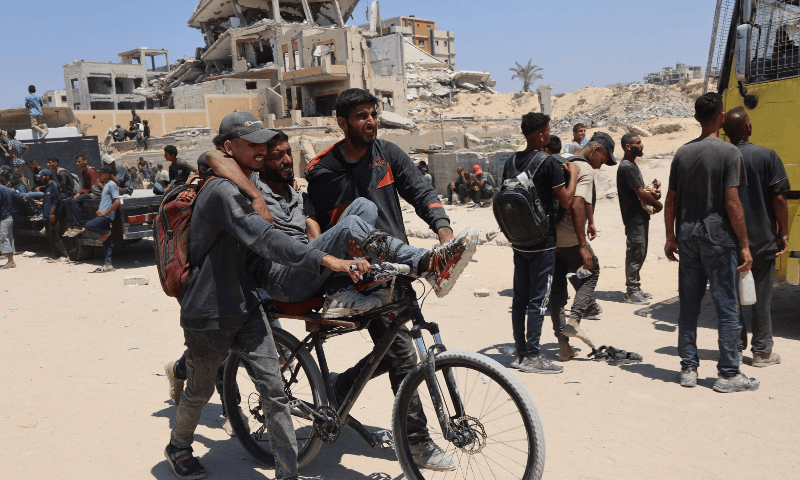  People transport a man, wounded as he waited for humanitarian aid, along al-Rashid street in western Jabalia on June 22, 2025, after trucks carrying humanitarian aid entered the northern Gaza Strip through the Israeli-controlled Zikim border crossing. &mdash; AFP 