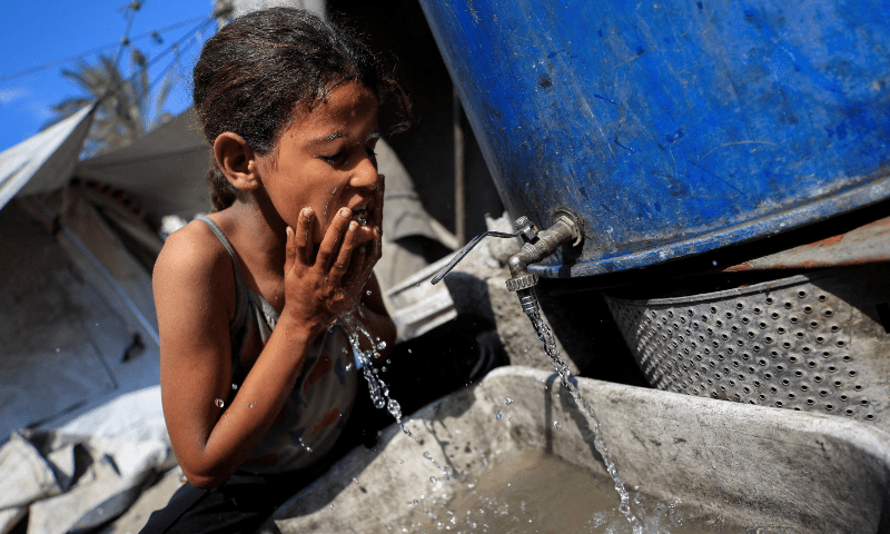 The daughter of displaced Palestinian man Akram Al-Manasra washes her face amid water shortages, outside their tent in Gaza City on July 14, 2025. — Reuters