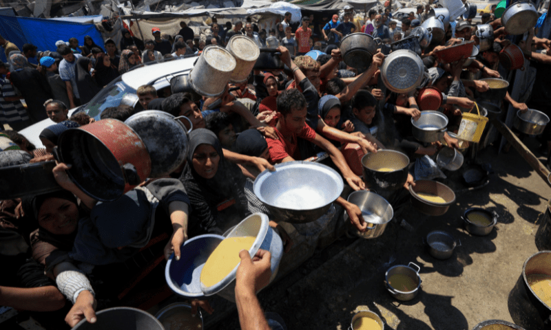  Palestinians gather to receive food from a charity kitchen, amid a hunger crisis, in Gaza City, July 25. &mdash; Reuters 
