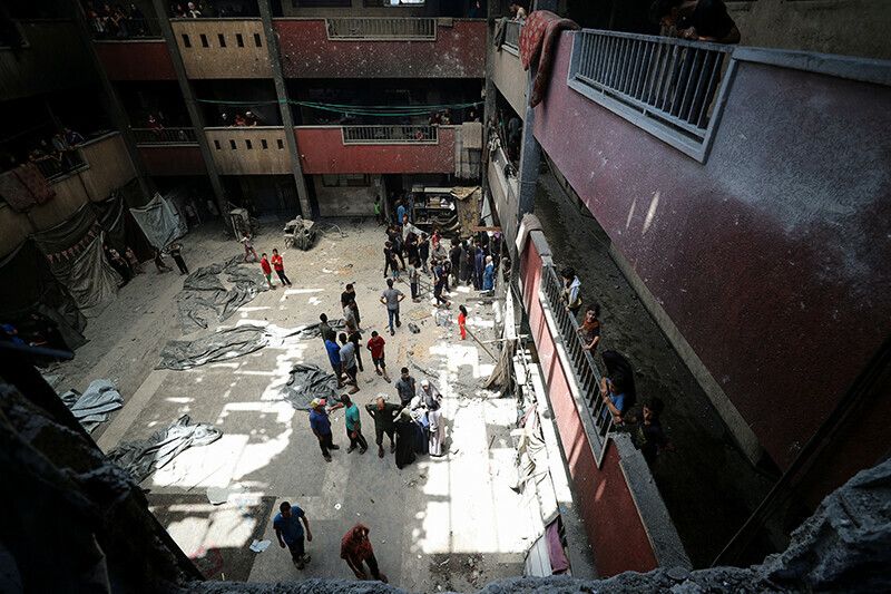 Palestinians gather at the site of an Israeli strike on a school sheltering displaced people, in Gaza City, July 25. &mdash; Reuters