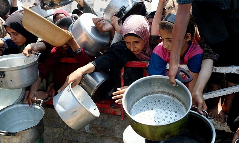Palestinians wait to receive food from a charity kitchen, amid a hunger crisis, in Gaza City on July 26, 2025. — Reuters