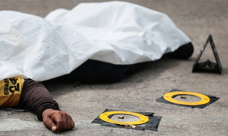 A body of a victim is seen covered at the crime scene after a shooting incident at a market in Bangkok, Thailand, July 28. &mdash; Reuters