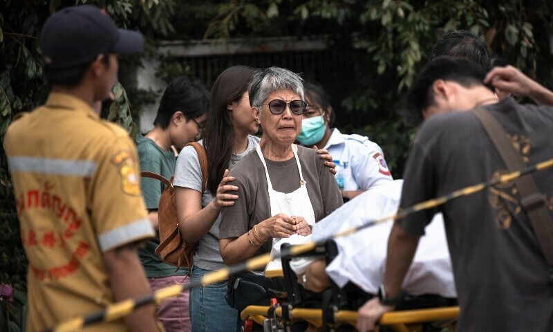 A woman reacts over the body of a shooting victim on a stretcherat a market in Bangkok, Thailand, July 28. &mdash; AFP