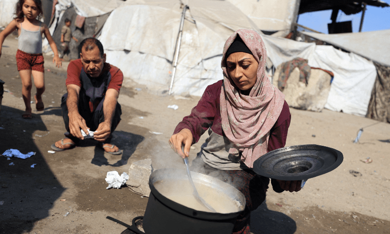 A woman cooks as displaced Palestinians who have not received humanitarian aid survive on leftover food, amid a hunger crisis in Gaza on July 28, 2025. &mdash; Reuters