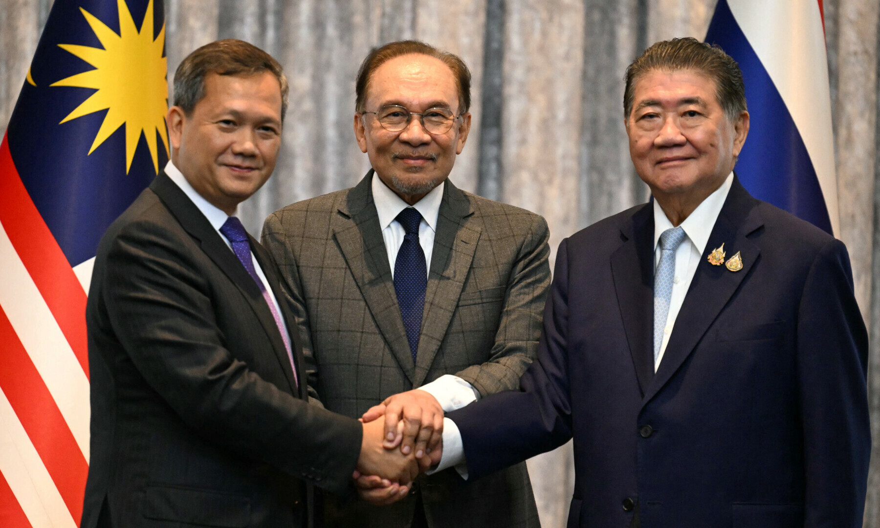Cambodia’s Prime Minister Hun Manet, Malaysia’s PM Anwar Ibrahim and Thailand’s acting PM Phumtham Wechayachai shake hands as they pose for photos following a press conference, on the day of mediation talks on the Thailand–Cambodia border conflict, in Putrajaya, Malaysia on July 28, 2025. — Mohd Rasfan/Pool via Reuters