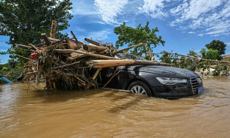 Debris and damaged cars are seen in a flooded neighbourhood in Miyun district, northern Beijing on July 29. &mdash; AFP