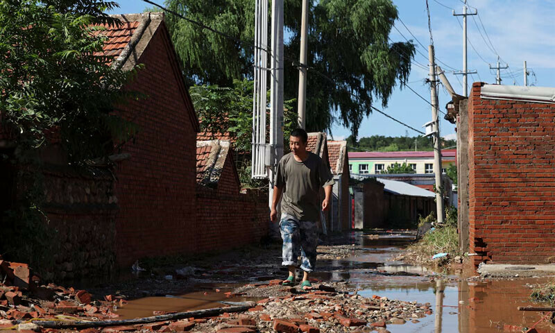 A man walks past village houses after heavy rainfall flooded the area in Miyun district of Beijing, China on July 29, 2025. — Reuters A man walks past village houses after heavy rainfall flooded the area in Miyun district of Beijing, China on July 29, 2025. — Reuters