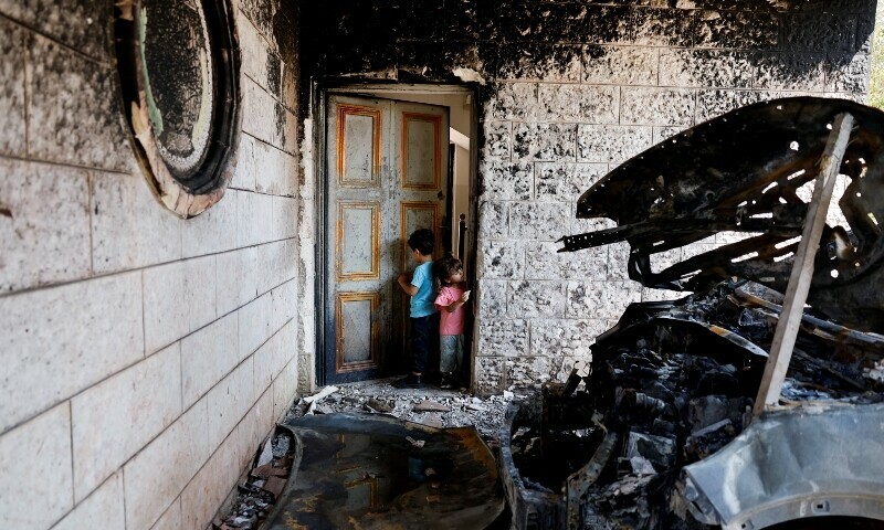 Palestinian children play next to a burnt car after an attack by Israeli settlers in Silwad village near Ramallah, in the Israeli-occupied West Bank, July 31. — Reuters