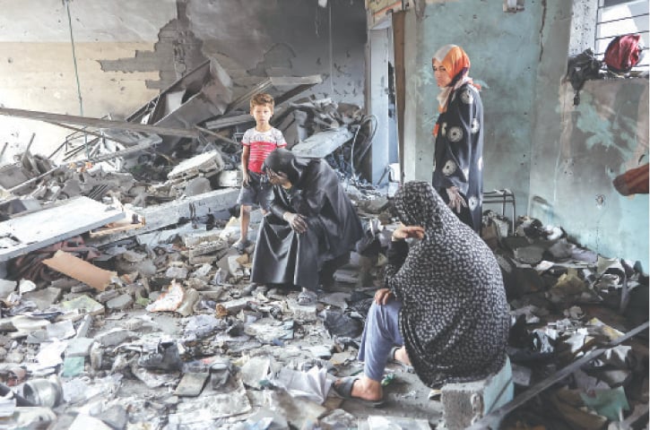  GAZA: Women grieve amidst the rubble of Yaffa School, which was destroyed in Israeli strikes.—AFP 