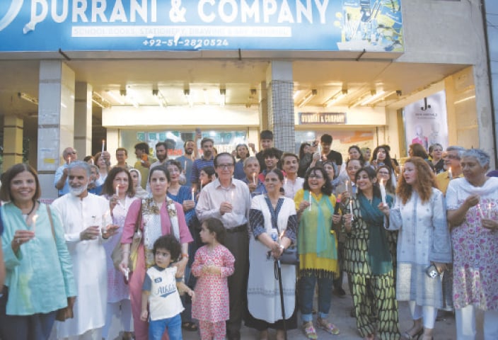 Members of the civil society hold a vigil outside the bookshop, Durrani & Company, which pulled down its shutters after around 50 years, in Islamabad on Monday. &mdash; Photo by Tanveer Shahzad