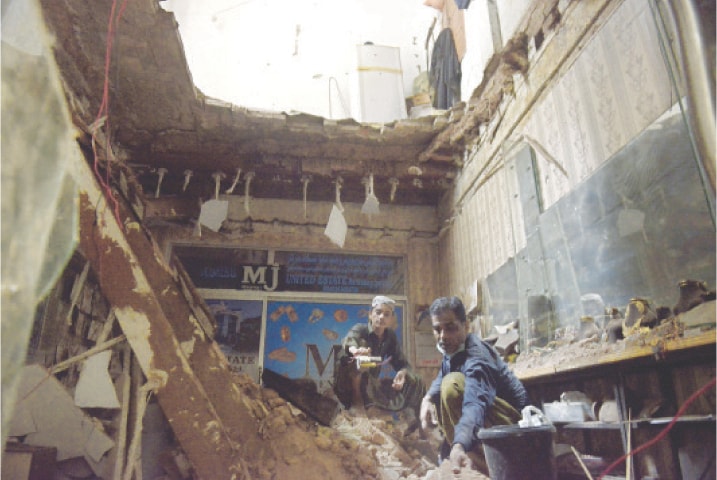 Workers at a jewellery shop look for their items buried in the debris of the roof of the dilapidated building in Rawalpindi’s Sarafa Bazaar. — Photo by Mohammad Asim