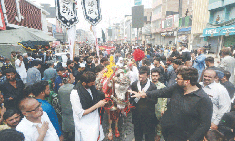 Mourners participate in a 9th Muharram procession in Peshawar on Saturday. — Photo By Shahbaz Butt