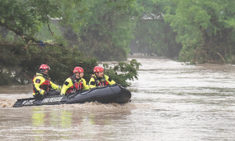 Rescue teams navigate upstream in an inflatable boat on the flooded Guadalupe River in Texas.—AFP