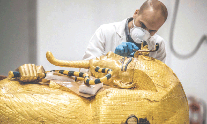 AN archaeologist performs restoration on the golden sarcophagus of Tutankhamun at a restoration lab of the newly-built Grand Egyptian Museum in Giza.—AFP