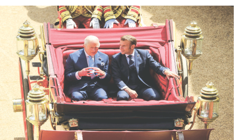 Britain&rsquo;s King Charles and French President Emmanuel Macron sit on a carriage as they arrive at Windsor Castle on Tuesday.&mdash;Reuters