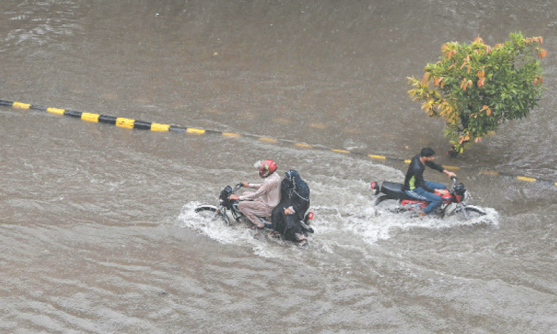 LAHORE: Motorcyclists wade through a submerged street after heavy monsoon rains resulted in urban flooding in many areas on Thursday.—AFP LAHORE: Motorcyclists wade through a submerged street after heavy monsoon rains resulted in urban flooding in many areas on Thursday.—AFP
