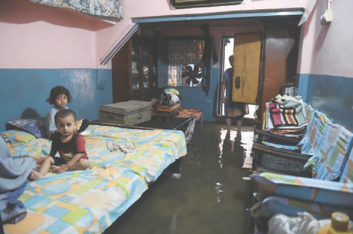  Sewer water enters the houses in Post and Telephone Colony, Samanabad, after the overflow of the main drain during downpour on Thursday. — White Star / Murtaza Ali 