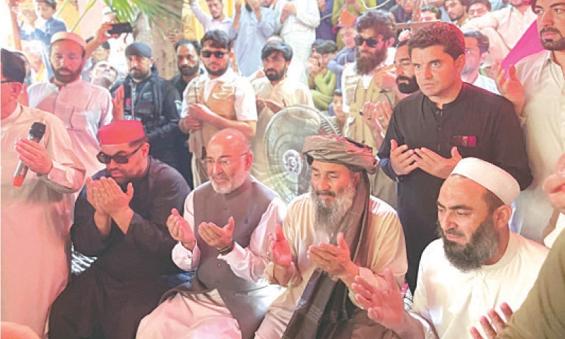 ANP central president Aimal Wali Khan and JI senior leader Mushtaq Ahmad Khan offer fateha for Maulana Khan Zeb in Nawagai, Bajaur, on Saturday. — Dawn