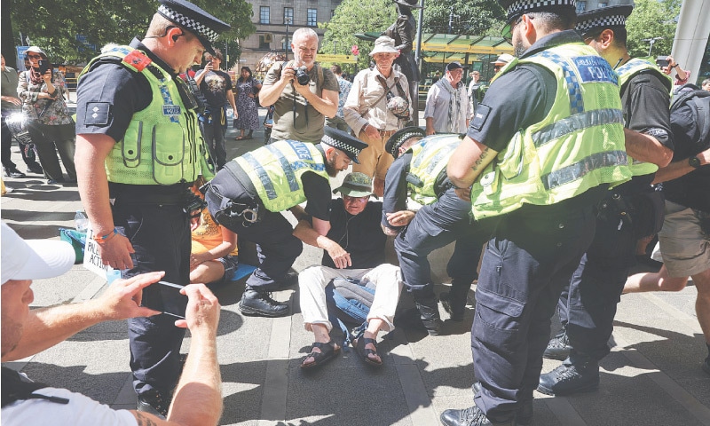 Manchester: Police officers try to remove a demonstrator during a protest calling for the de-proscription of the Palestine Action group on Saturday.—Reuters