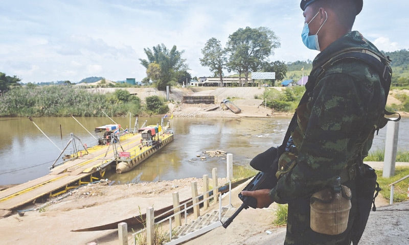 A THAI soldier guards a river crossing between Thailand and Myanmar in the border town of Mae Sot in Tak province.—AFP/File