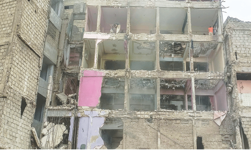 Labourers demolish a multi-storey building in Lyari, adjacent to the one that collapsed on July 4, after the Sindh Building Control Authority declared it “unsafe” and evacuated its residents.—Fahim Siddiqi / White Star