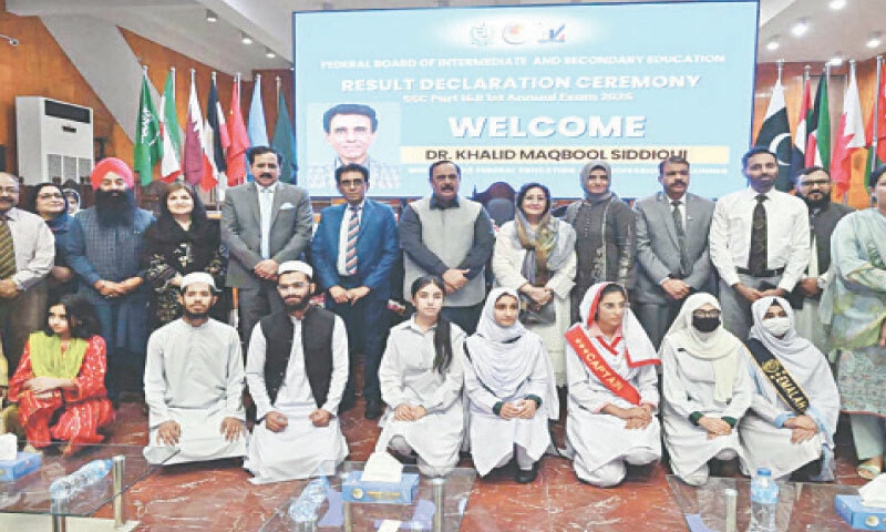 Education Minister Dr Khalid Maqbool Siddiqui poses for a group photograph with position holders during a ceremony at the FBISE in Islamabad on Wednesday. — APP