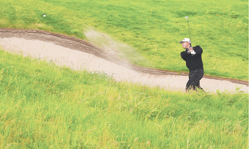 PORTRUSH: Japan’s Hideki Matsuyama plays out from a bunker on the first hole during the opening round of the 
British Open at the Royal Portrush Golf Club on Thursday.—Reuters