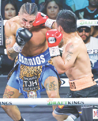 MANNY Pacquiao (R) of the Philippines lands a punch on Mario Barrios of the US during their WBC welterweight title fight at the MGM Grand Garden Arena.—AFP