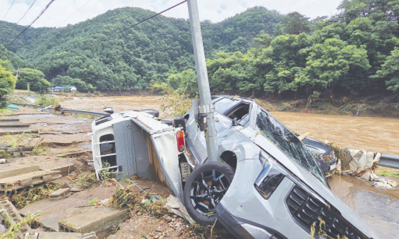 Cars damaged by floodwater are seen on a road along the river due to heavy rain in Gapyeong county on Sunday.—AFP Cars damaged by floodwater are seen on a road along the river due to heavy rain in Gapyeong county on Sunday.—AFP