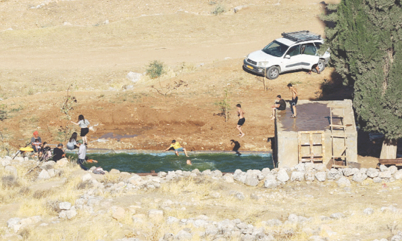 Israeli settlers swim in the Ein Samiyah spring near the village of Kafr Malik.&mdash;AFP