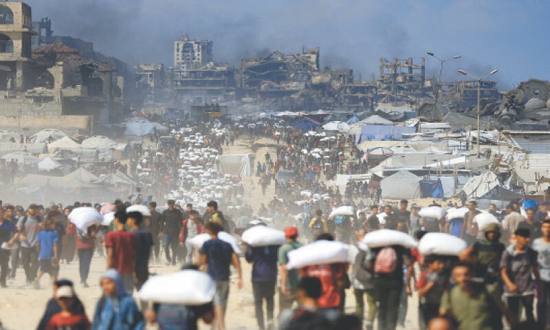 PALESTINIANS carry food bags in Beit Lahia, northern Gaza, as supplies entered the besieged enclave over the weekend.&mdash;Reuters